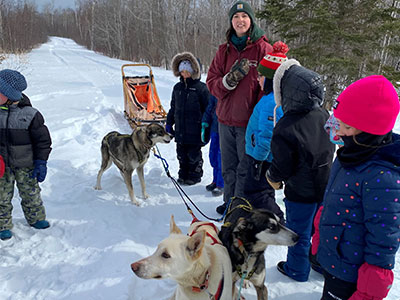 lady and students beside dogsled