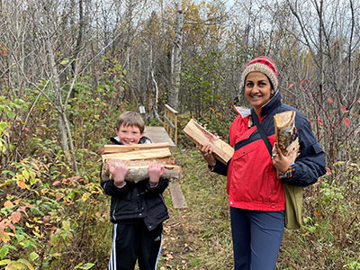 lady and student gathering wood