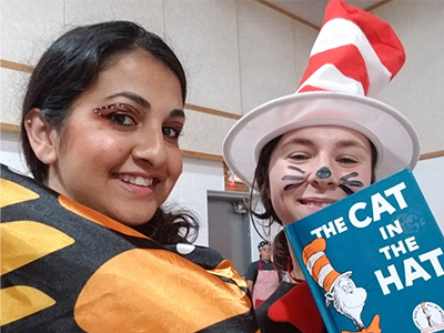 two females in costume holding The Cat in the Hat book